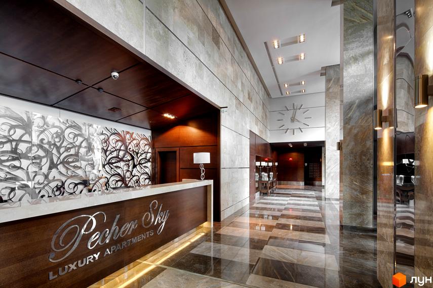 Сучасний інтер'єр рецепції житлового комплексу PecherSKY з елегантними матеріалами та освітленням.