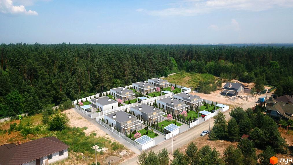 Котеджне містечко КМ Лісові Гореничі: сучасні будинки з сірими дахами та білими фасадами, огороджена територія з газоном та деревами.