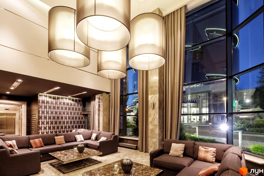 Сучасний інтер'єр житлового комплексу PecherSKY з великими вікнами та комфортними зонами для відпочинку.