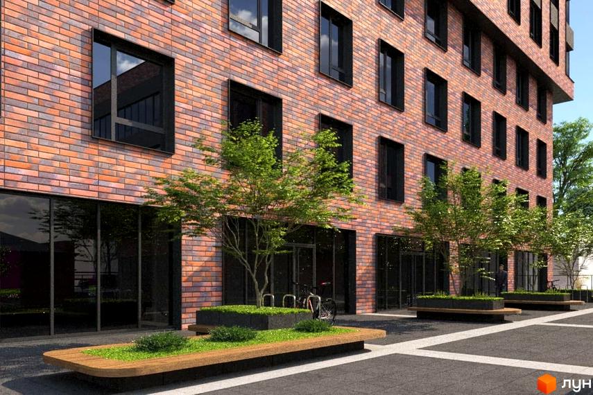 Фасад житлового комплексу на вул. Гончара, 38-42 з цегляною кладкою та темними вікнами. Прибудинкова територія з лавками та зеленими насадженнями.