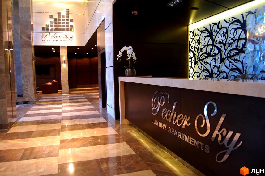 Внутрішній інтер'єр житлового комплексу PecherSKY з сучасним оформленням та елегантною рецепцією.