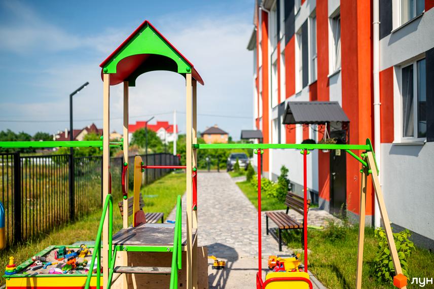 Житловий комплекс Smart Format з яскравим фасадом та дитячим майданчиком. На території є пісочниця, гойдалки та лавки.