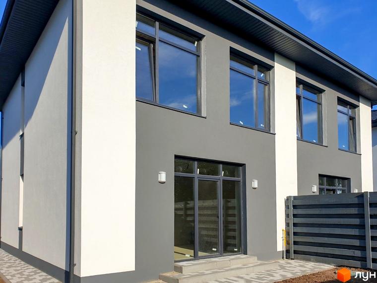 Зовнішній вигляд двоповерхового будинку з сірими та білими фасадами, великими вікнами та прибудинковою територією з парканом. Адреса: вул. Шкільна, 2.