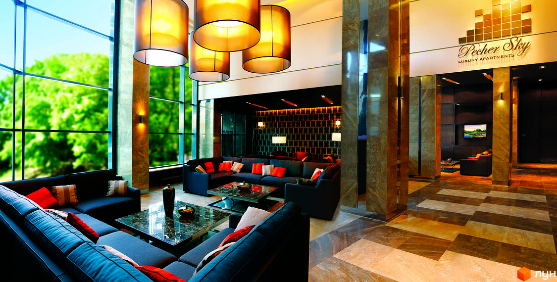 Сучасний інтер'єр житлового комплексу PecherSKY з комфортною зоною для відпочинку та великими вікнами, що виходять на зелену територію.