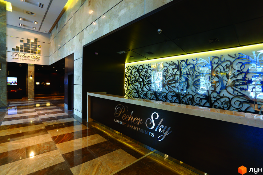 Внутрішній вигляд рецепції житлового комплексу PecherSKY з елегантним дизайном та сучасними матеріалами.