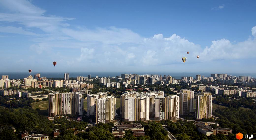 Вид на новобудову KADORR City з повітряними кулями. Комплекс складається з висотних будівель з біло-золотими фасадами, оточених зеленню.