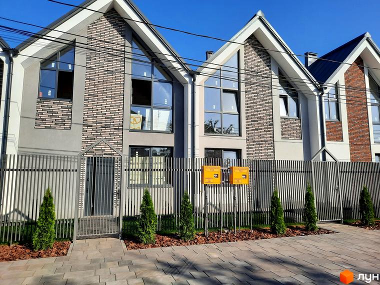 Зовнішній вигляд будинків у Котеджному містечку Villa Gatne. Вигляд на фасад будинку та прибудинкову територію.