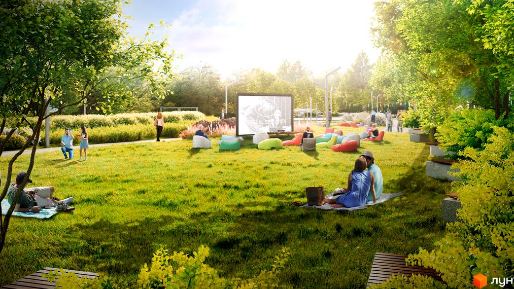 Відкритий кінотеатр на території ЖК 7 KVARTAL. Зелена зона з газоном, лавками та великим екраном для перегляду фільмів.
