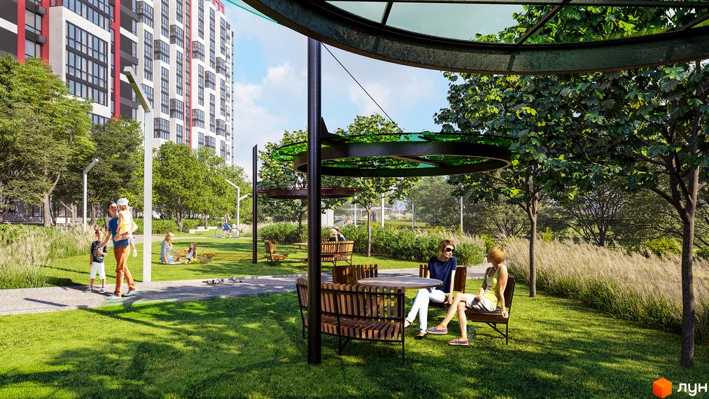 Житловий комплекс 7 KVARTAL з сучасними будинками та зеленими зонами для відпочинку. Простора прибудинкова територія з лавками та столиками.