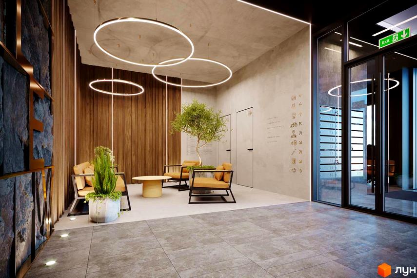Вестибюль житлового комплексу Life Story з круглими стельовими світильниками, кам'яною стіною та зоною відпочинку.