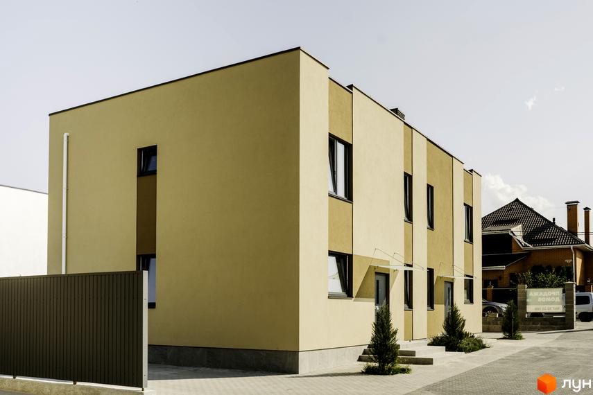 Котеджне містечко КМ My Land: двоповерхові будинки з коричневим та бежевим фасадом, вікнами та дверима. Прибудинкова територія з бруківкою та зеленими насадженнями.