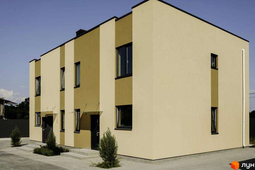 Зовнішній вигляд двоповерхових будинків КМ My Land з бежевим та золотистим фасадом, вікнами та дверима. Поруч розташовані зелені насадження та бруківка.