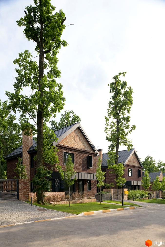 Котеджне містечко Oak Grove Town. Цегляні будинки з темними дахами та великими вікнами, оточені високими деревами. Доглянутий газон та вимощені доріжки.