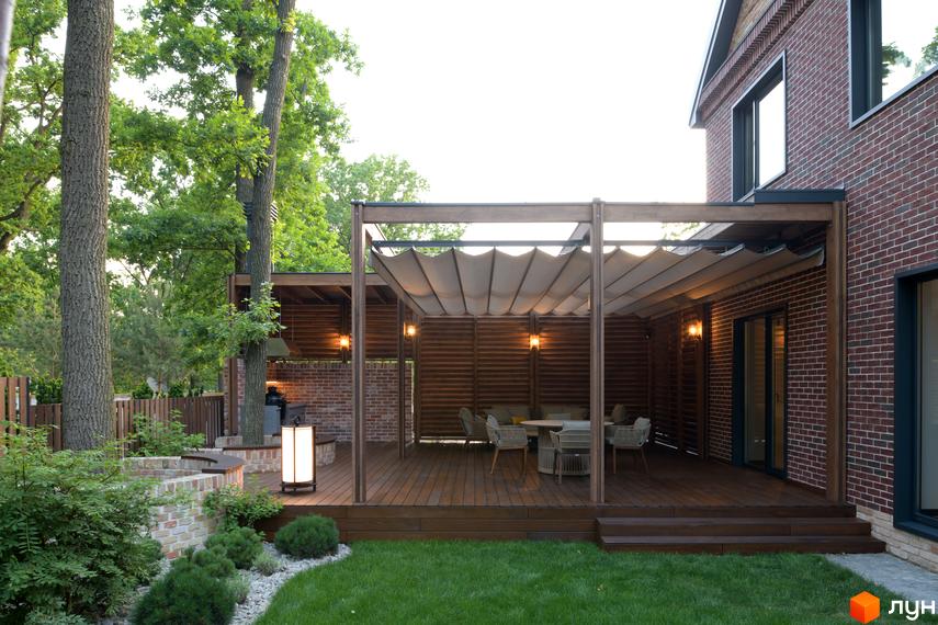 Затишний будинок з терасою та зоною відпочинку. На території КМ Oak Grove Town розташована зелена галявина та декоративні рослини.