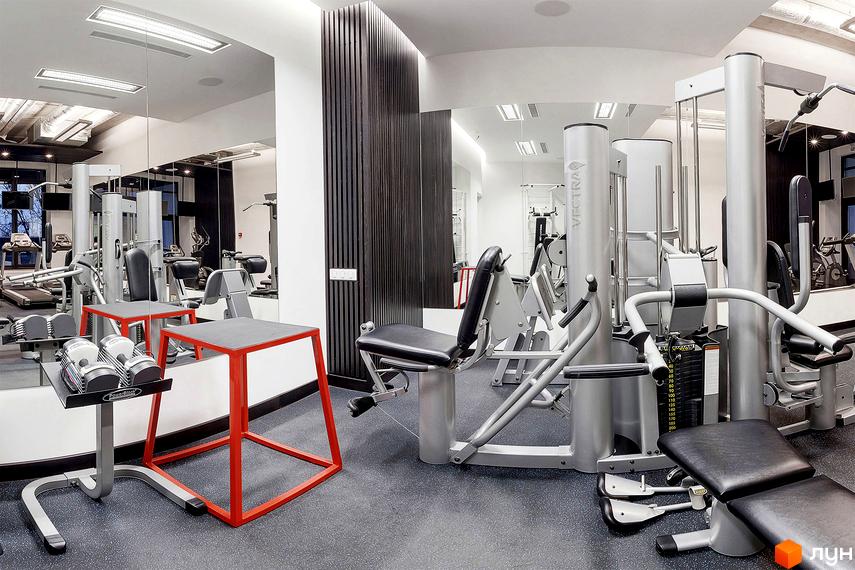 Сучасний тренажерний зал у житловому комплексі Skyline з різноманітними тренажерами та вільними вагами. Простір обладнаний для ефективних тренувань.