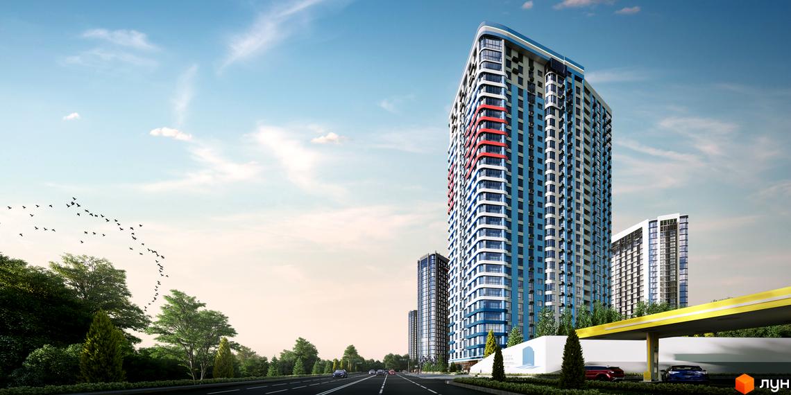 Житловий комплекс Берег Дніпра з блакитними та червоними елементами фасаду на тлі хмарного неба. Поруч дорога з автомобілями та зелені насадження.