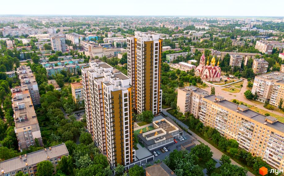 Високі будинки ЖК Городок з фасадами в світлих тонах, поруч зелені насадження та дитячий майданчик. Вид на місто з висоти пташиного польоту.