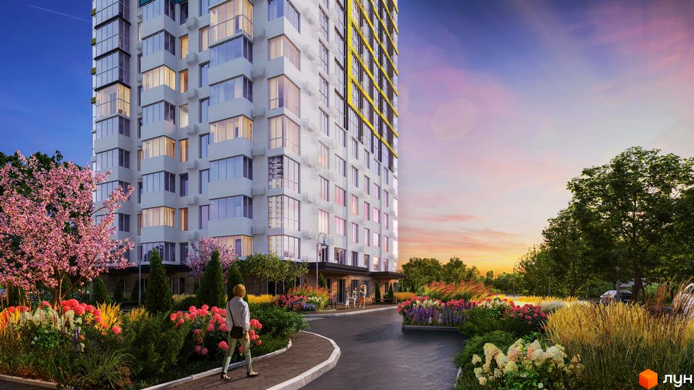 Новобудова ЖК Теремки з фасадом з білої цегли та жовтими елементами. Навколо будинку розташовані квітучі дерева та кущі, доріжка для пішоходів та проїжджа частина.