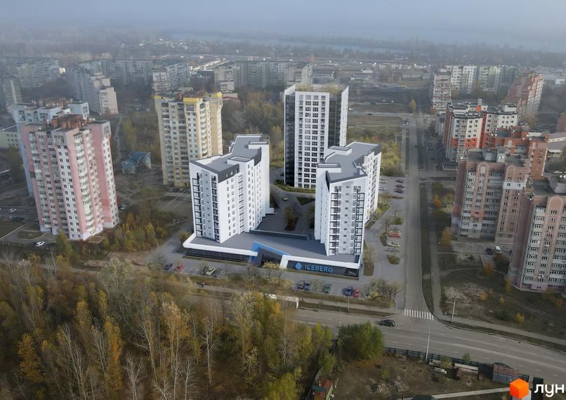 Зовнішній вигляд новобудови ЖК Iceberg з білими фасадами та сірими дахами. Навколо комплексу розташовані паркувальні місця та зелені насадження.