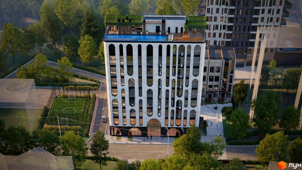 Висотна будівля з панорамними вікнами та басейном на даху. Поряд з будинком розташовано футбольне поле та зелені насадження.