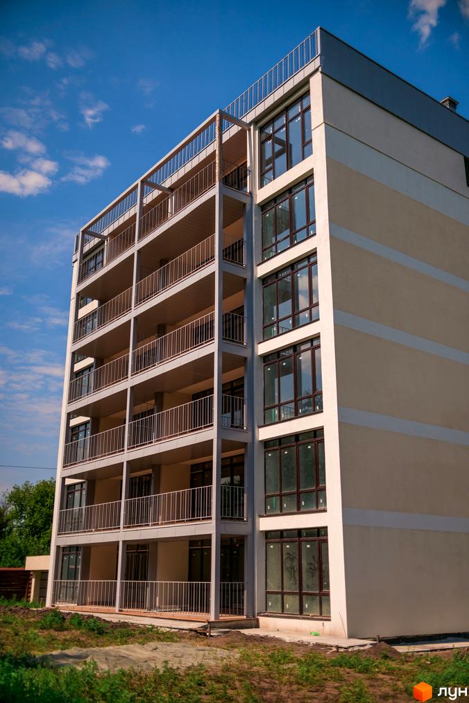 Будівельний проєкт Summerville з балконами та великими вікнами на тлі блакитного неба. Навколо новобудови видно будівельний майданчик та зелень.