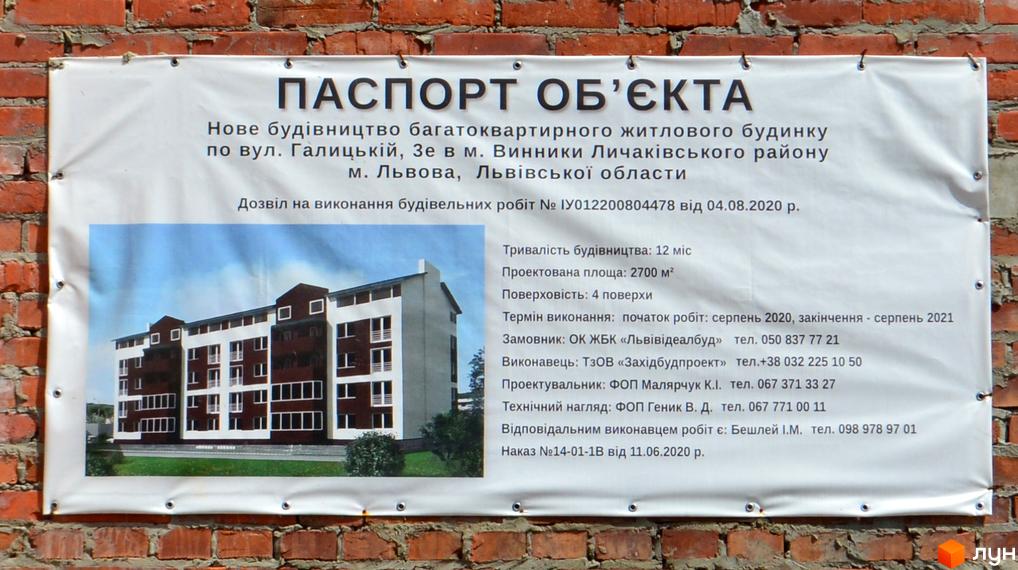 Зовнішній вигляд житлового комплексу на вул. Галицькій, 3е: чотириповерховий будинок з червоно-білим фасадом та балконами. Навколо будинку зелена територія з деревами.