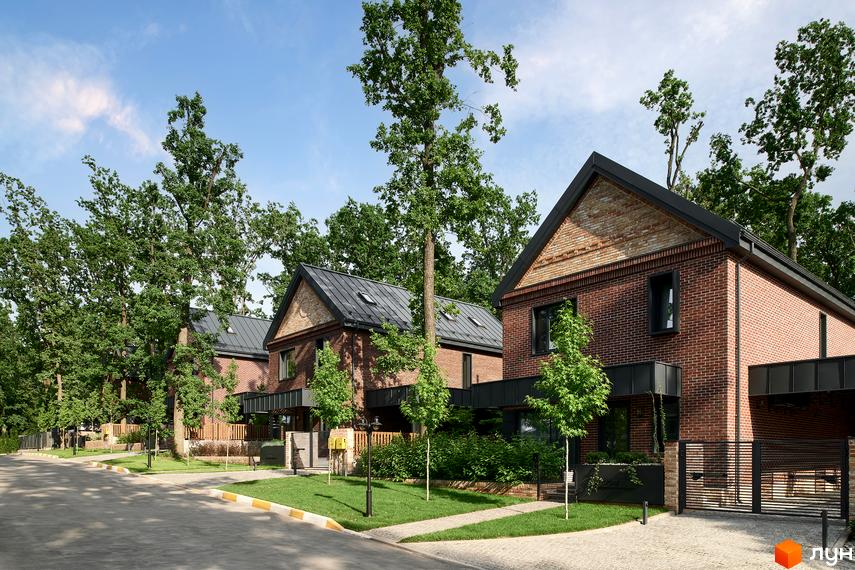 Котеджне містечко Oak Grove Town: ряд цегляних будинків з темними дахами та вікнами, оточених зеленими газонами та деревами вздовж дороги.