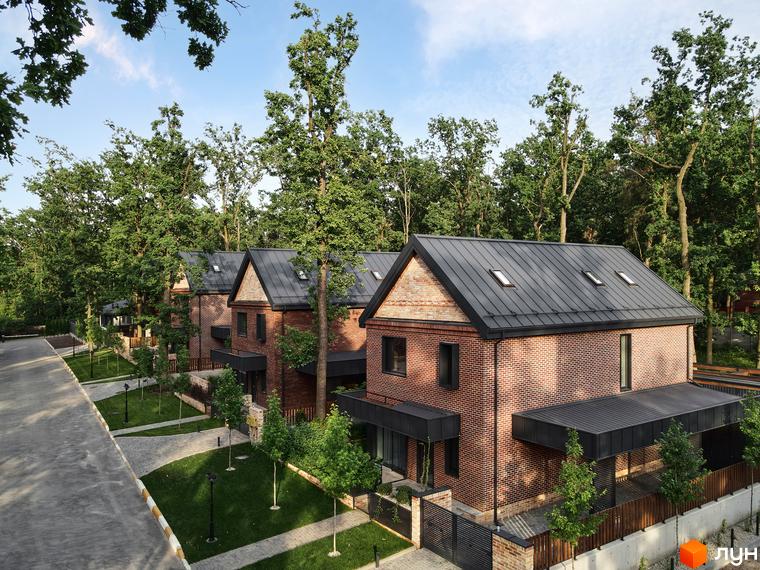 Котеджне містечко Oak Grove Town. Цегляні будинки з темною покрівлею та чорними вікнами. На території зелені газони, доріжки та дерева.