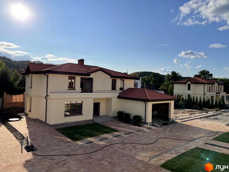 Котеджне містечко Фонтан: двоповерхові будинки з червоними черепичними дахами та світлими фасадами, огороджена територія з бруківкою та зеленими насадженнями.