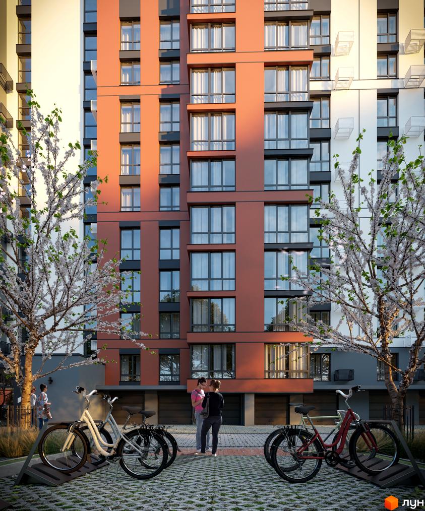 Фасад Житлового комплексу Молодіжний з теракотовими та світлими секціями, великими вікнами. Двір з квітучими деревами та велопарковками.