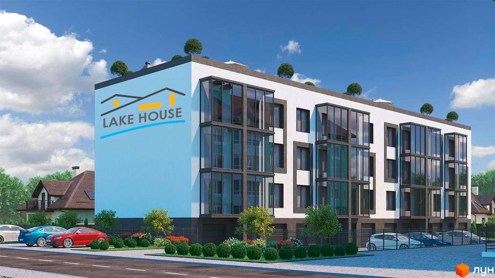 Зображення Житлового комплексу Lake House з білим фасадом, великими вікнами та блакитною стіною з логотипом. Перед будинком парковка та зелені насадження.