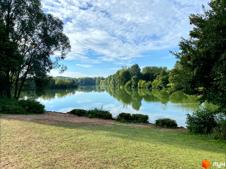 Котеджне містечко BELLAGIO біля озера з деревами та зеленою галявиною. Спокійний відпочинок на природі.