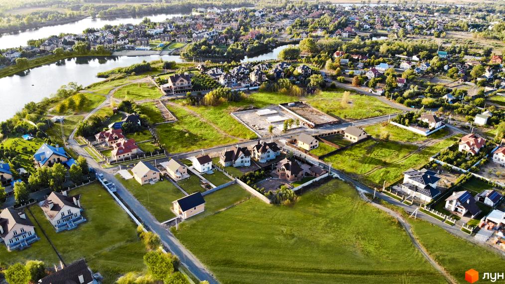 Вид на будинки Котеджне містечко Зоряний. Простора територія з газонами, озелененням та котеджами з різними архітектурними рішеннями.
