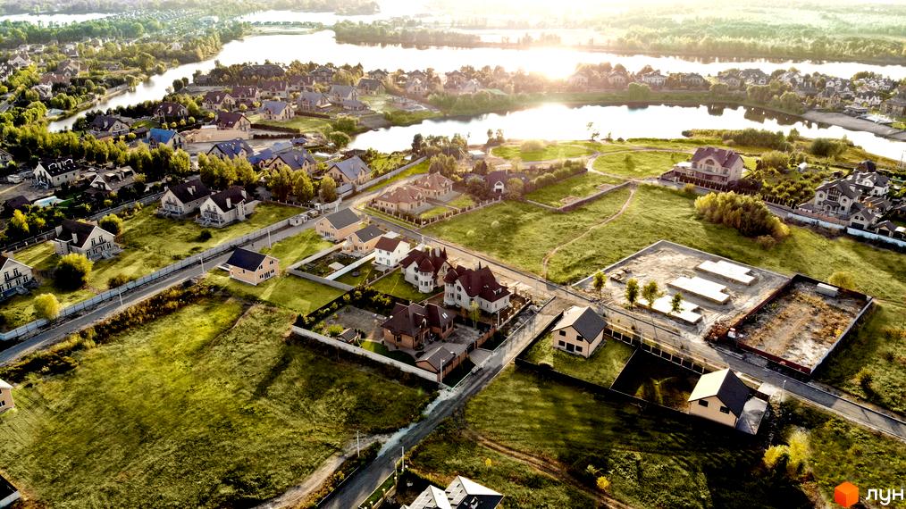 Вид зверху на будинки в Котеджному містечку Зоряний. Простора прибудинкова територія та мальовнича місцевість навколо.