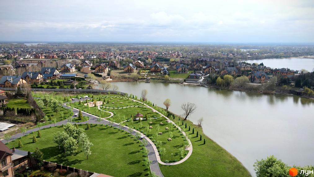 Котеджне містечко Зоряний: затишні будинки біля озера з доглянутою зеленою територією та зонами відпочинку.