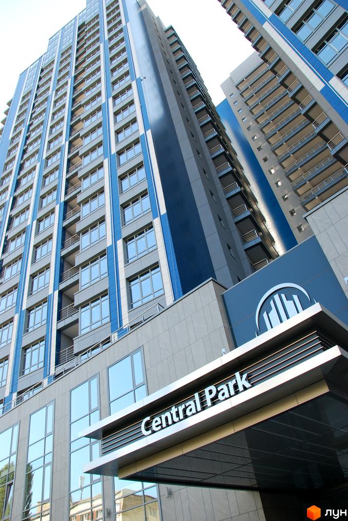 Житловий комплекс Central Park з сучасною фасадною обробкою та великими вікнами, прибудинкова територія з зеленими насадженнями.