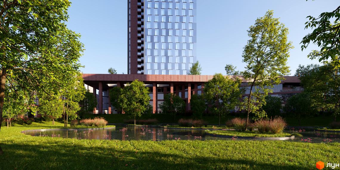 Висотна будівля БФК MAYAK з скляним фасадом на фоні блакитного неба, перед будівлею розташований ставок та зелена територія.