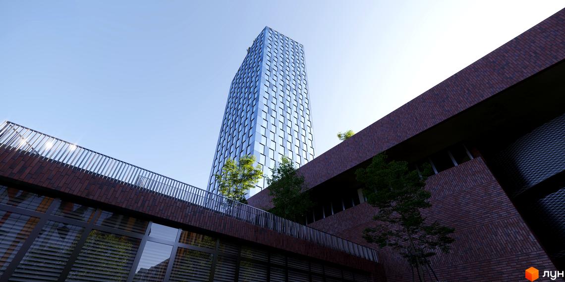 БФК MAYAK - це висотна будівля зі скляним фасадом та цегляною обробкою, що оточена зеленню та має балкон з металевою огорожею.