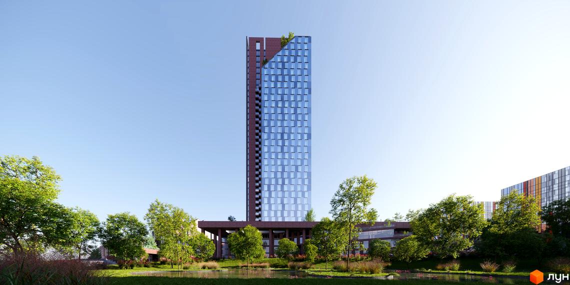 Висотна будівля БФК MAYAK з скляним фасадом на тлі блакитного неба. На передньому плані зелені дерева та водойма.