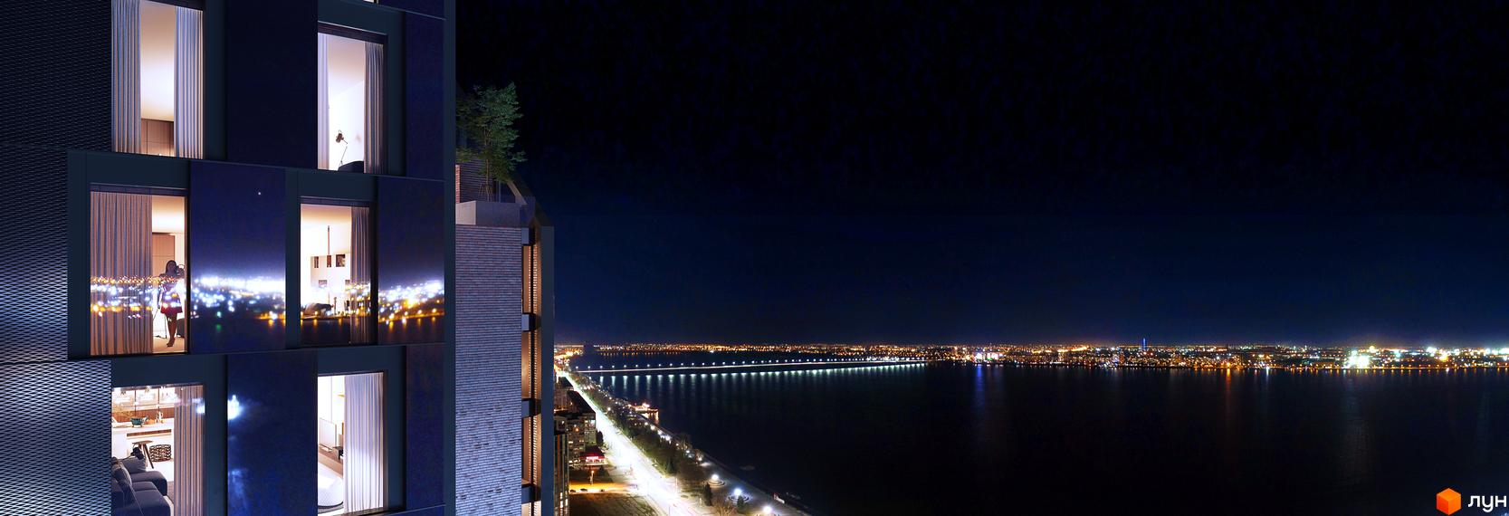 БФК MAYAK: нічний вид на новобудову з вікнами, що виходять на місто та річку. Навколо будинку розташована міська набережна з освітленням.