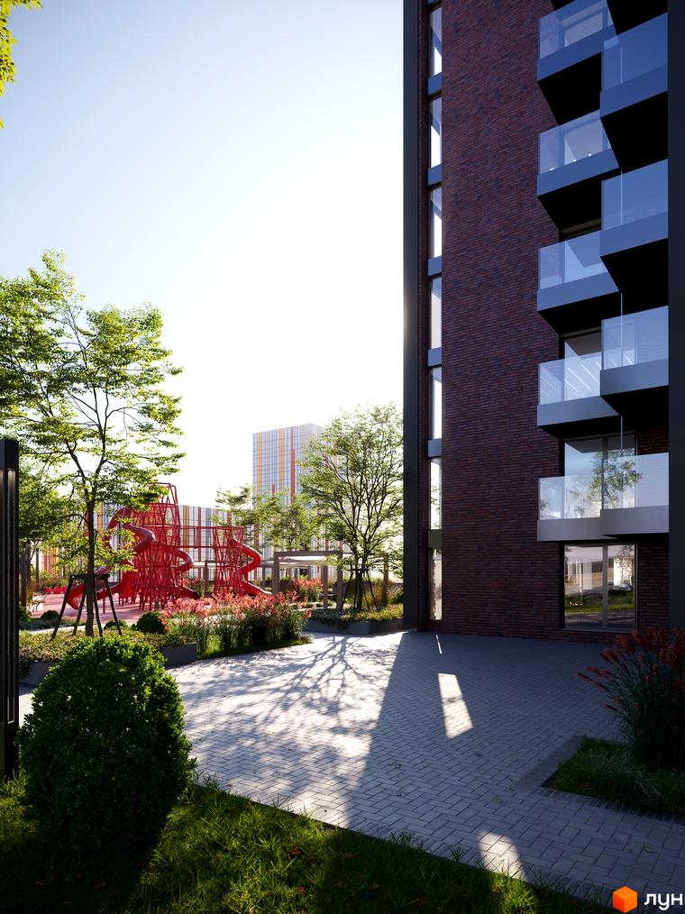 Зовнішній вигляд будинку БФК MAYAK з цегляним фасадом та балконами. На прибудинковій території дитячий майданчик та зелені насадження.