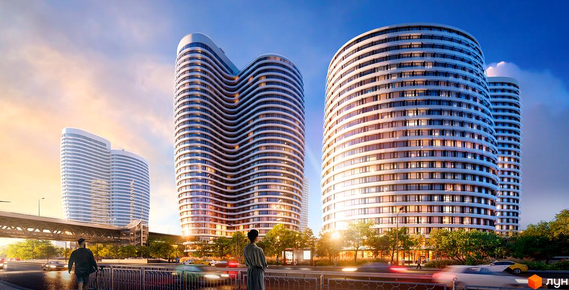Житловий комплекс OASIS з хвилястими фасадами та скляними балконами на тлі неба. Навколо комплексу зелені дерева та міська інфраструктура.