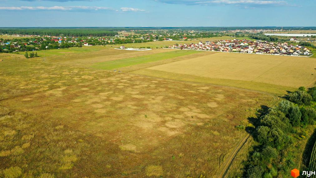 Котеджне містечко КМ Луговий з сучасними будинками та доглянутою прибудинковою територією, що потопає в зелені.
