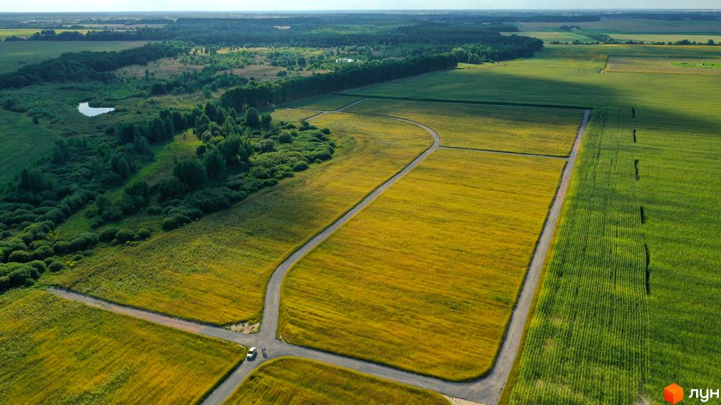 Вид зверху на Котеджний квартал „Фортеця Колонщини“. На зображенні видно поля та дороги, що ведуть до котеджів.