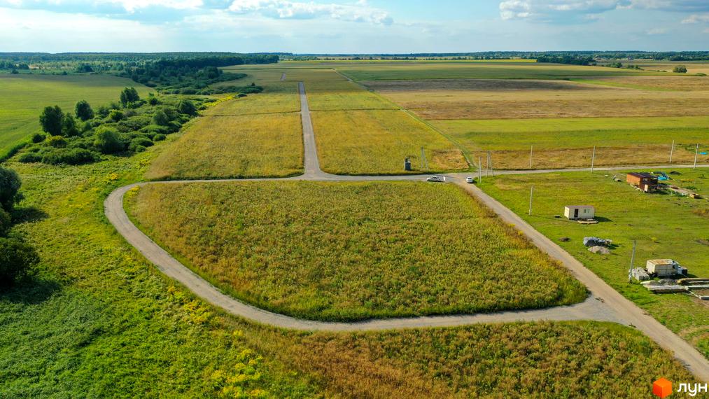 Вид на Котеджне містечко „Фортеця Колонщини“ з висоти пташиного польоту. На зображенні видно ділянки землі з під'їздними шляхами та будівлі.