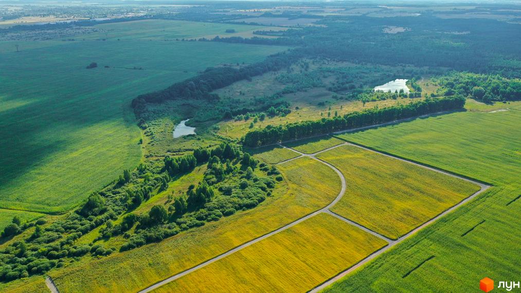 Вид зверху на КМ «Фортеця Колонщини». На передньому плані поля з різними культурами, далі ліс та водойма. Дороги між полів.