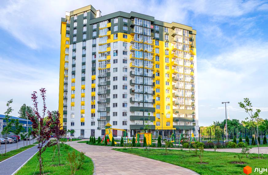 Житловий комплекс Сирецькі сади - яскрава новобудова з жовтими та білими фасадами. Поруч дитячий майданчик та зелена зона відпочинку.