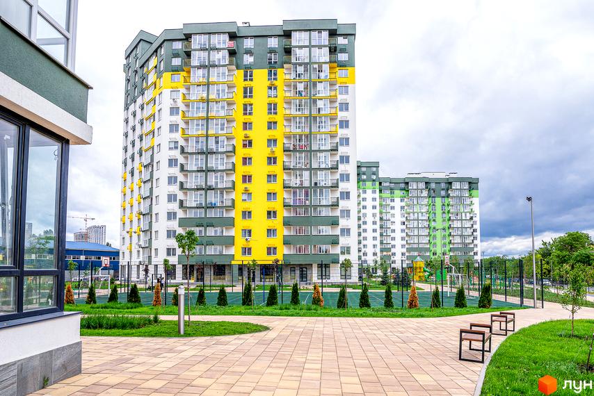 Новобудова ЖК Сирецькі сади з яскравим фасадом жовто-зеленого кольору. На прибудинковій території облаштований дитячий майданчик та спортивні зони.