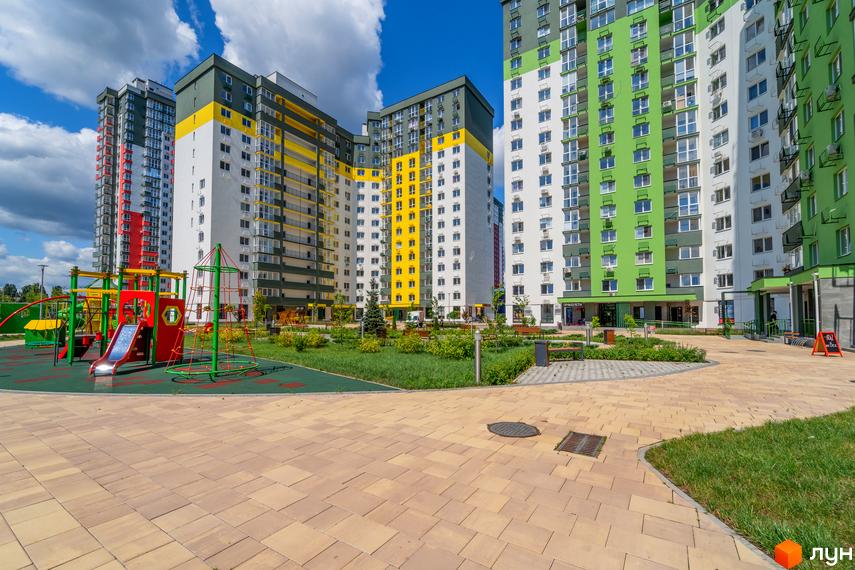Житловий комплекс Сирецькі сади з яскравими фасадами та дитячим майданчиком. Сучасна новобудова з озелененою прибудинковою територією.