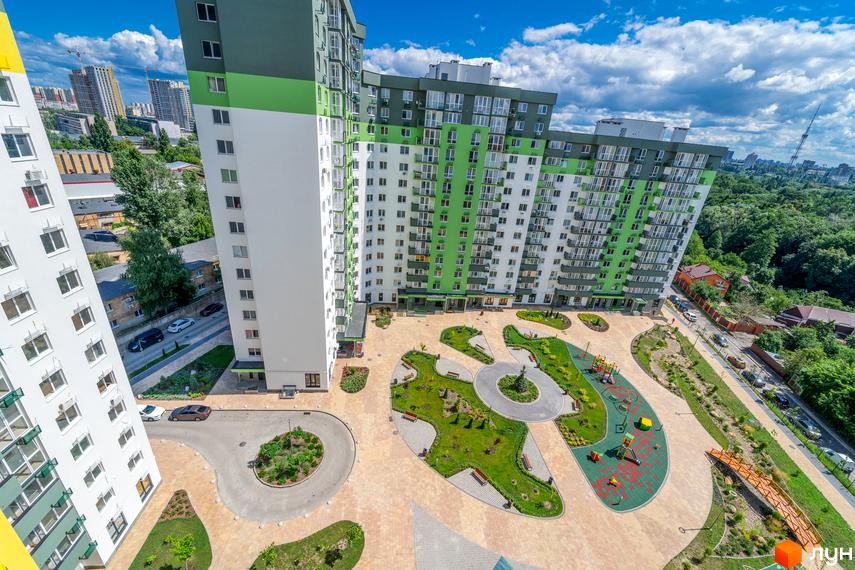 Вид на житловий комплекс Сирецькі сади з висоти пташиного польоту. Сучасна архітектура будівель та доглянута прибудинкова територія з дитячим майданчиком та зонами відпочинку.
